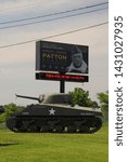 Small photo of May 27, 2016, Fort Knox, KY, George Patton Museum, billboard sign above a Sherman tank with a destroyed tank turret