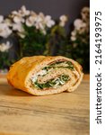 Small photo of Baked pizza roll stuffed with rocket, raw ham, cheese flakes and buffalo stracciata served for lunch in a rotisserie