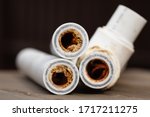 Old broken sludge polypropylene plumbing pipes with red rust and limescale. Corrosion, sludge and hard water concept. Rust broken water pipes