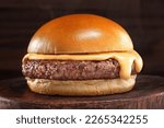 hamburger with cheddar cream and fresh and tasty brioche bun on smoke and dark wooden table.
