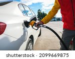 Small photo of Man pumping gasoline fuel in car at gas station and being fill gas tank of white car in gas station, Concept of Global Fossil Fuel Consumption, Rising gasoline prices, Copy Space.