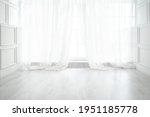 Backlit window with white curtains in empty room