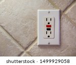 Small photo of Ground fault interrupter electricity receptacle and wall plate. Residential electric socket plug with GFI reset button.