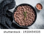 Fried mince beef and lamb meat in a pan with herbs. White background. Top view