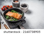 Small photo of Salmon fillets, grilled steaks in skillet with herbs. White background. Top view. Copy space.