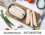 Small photo of Canned Mackerel Fillets in Tin set, on wooden cutting board, on white background with herbs and ingredients, top view flat lay