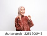 A beautiful hijab woman wearing brown jacket showing smile face and presenting and pointing at the copy space beside her in the isolated white background