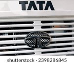 Small photo of Jhargram, West Bengal - November 24, 2023:Big chrome-plated Tata logo positioned on the front area of a Tata truck's cowl represents the brand's identity,as it's a symbol of reliability and strength.