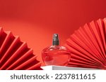 Perfume bottle with paper fan. Concept of expensive perfume and cosmetics. Floral fragrance for women. Perfume spray. Modern luxury lady parfum de toilette