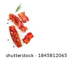 Single fried crispy bacon slices and rosemary sprig isolated on white background. Top view. Copy space.