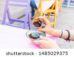 Small photo of young woman at the cafe turning a cup of coffee.Believing that coffee cups will show the future. The future in a cup of coffee. Prophesying fate.