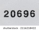 Small photo of Black Number 20696 on the white wall. Spray paint.two thousand six hundred ninety-sixtwo thousand six hundred ninety-six