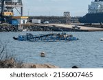 Small photo of SINES, PORTUGAL - May 04, 2022: The men working on the water next to the Natural Gas Terminal in the Port of Sines, Portugal
