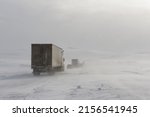 A row of trucks follow a snow blower on Canada