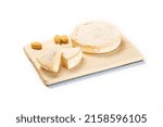 Small photo of A wooden plank with a truckle of cheese with slices and bread isolated on the white background