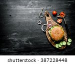 Burger On A Cutting Board With...
