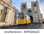 A famous yellow tram 28 passing in front of Santa Maria cathedral in Lisbon, Portugal