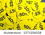 Yellow round stickers with discounts of 10 to 50 percent. Sell-out. Discounts on a black background. Black Friday. Price fall. Posters. Macro discounts