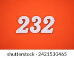 Small photo of Orange felt is the background. The numbers 232 are made from white painted wood.