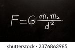 Small photo of Newton's law of gravity formula handwritten on a blackboard with chalk