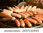 Small photo of grilled sausage meat stabbing in wooden stick on gridiron street food in China