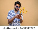 Young man using smartphone sending emojis. Outdoors. Social media concept.
