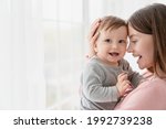 Small photo of Cheerful smiling mother and little baby kid child. Family motherhood moments. Nanny childminder holding small toddler newborn baby infant with love and care. Adoption and IVF
