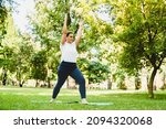 Small photo of Slimming burning calories exercises. Caucasian plump young woman athlete in fitness clothes doing yoga on fitness mat outdoors in park.