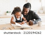 Small photo of African-american father dad tutor childminder helping assisting with homework school project to a preteen daughter student. Homeschool concept. E-learning