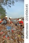 Small photo of jepara, central java, indonesia, 07 may 2023, three people sorting garbage in a seedy river