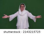 An Asian Muslim woman dressed in white greets her visiting family.