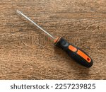 A flat head screwdriver on a wood background