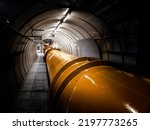 Illuminated gas or oil, orange pipeline in dark tunnel.