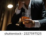 Small photo of Businessman sitting Holding a Glass of Whiskey Drink Whiskey in the liquor store room