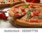 Tasty pizza and ingredients on wooden background