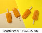 Mango or caramel ice cream sticks on color background