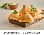 Fatayer pie samosa with white cheese and meat on wooden board. Closeup