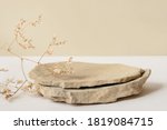 Background for cosmetic products of natural beige color. Stone podium and dry flower on a white background. Front view.