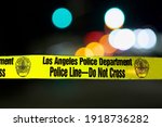 Small photo of Los Angeles - January 2, 2021: Police barricade tape illuminated night exterior with deliberately blurred bakground