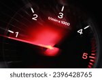 Motion blur of a car instrument panel dashboard odometer with red illuminated display.Car speedometer. High speed car speedometer and motion blur at night.