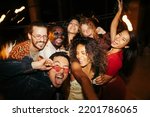 A group of multiracial friends has a great time at the roof nightclub in the summertime. Clubbing, fun, and parties during the summer concept.
