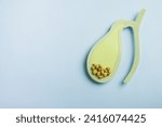 Gallbladder decorative model with gallstones on pastel blue background. Gallbladder disease concept. Top view, copy space