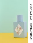 Small photo of 03 07 2021: Perfume, a mixture of fragrant essential oils or aroma compounds, with an agreeable scent. Modern green bottle with brand on shining yellow and green background