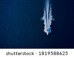 Large speed boat moving at high speed. Top view of a white boat sailing to the blue sea. Drone view of a boat sailing. Motor boat in the sea. Travel - image.