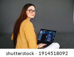 Portrait of young woman mobile developer with laptop, writes program code on a computer, programmer work.