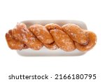 Small photo of Above top vie of Cinnamon glazed twist donut on rectangular porcelain plate. Popular snack food. National and International Donut day treat.