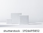 White square podiums in sunlight with shadow on white background. Trend fashion showcase for cosmetic products, goods, shoes, bags, watches.