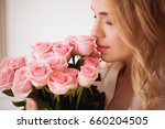 Beautiful blond woman holds pink roses