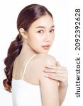 Small photo of Asian woman with a beautiful face gathered in a brown ponytail and clean fresh smooth skin. Cute female model with natural makeup and sparkling eyes on white isolated background.