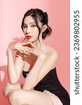Fashionable Asian woman have good figure and clear fresh skin in black trendy dress pose on isolated pink background. Plastic Surgery, Concept of beauty, body and skin care, health, spa, cosmetics.